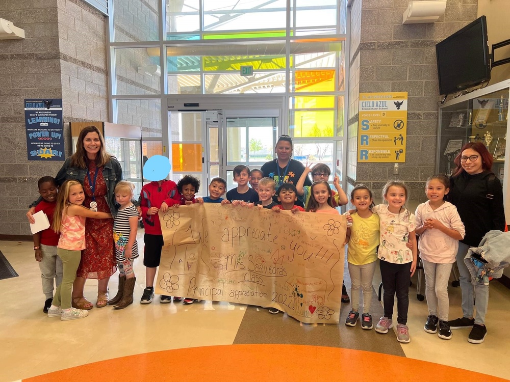 Students at CAE present Principal Banes with a thank you banner they made for her