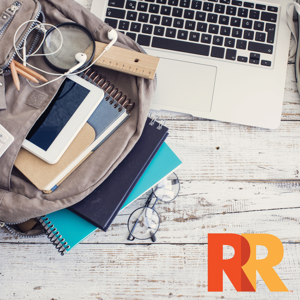 Photo of a backpack with ear phones, a laptop, books and glasses