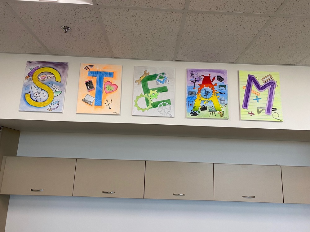 The word "STEAM" spelled out with student artwork.