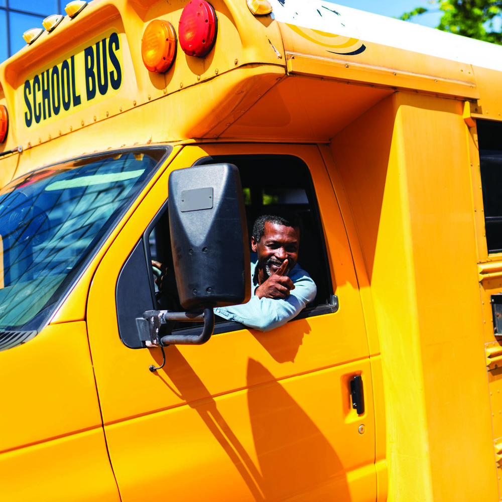 School bus driver waving out his window