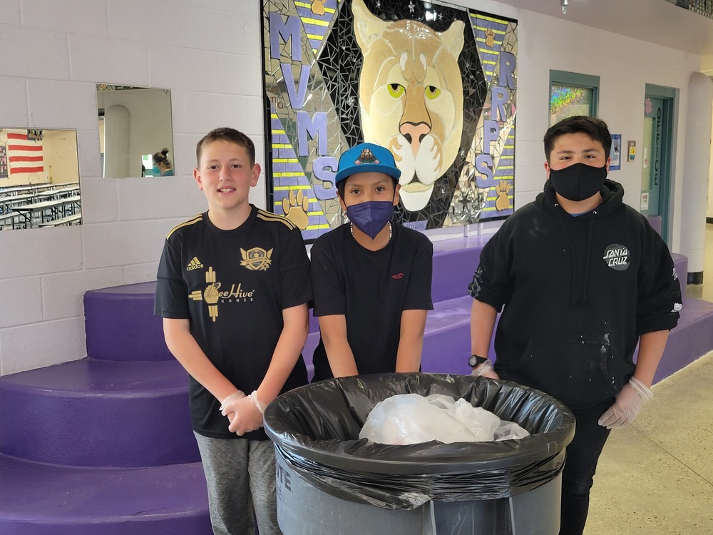 Three students from the MVMS Sanitation Club pose for a photo as they prepare to empty a trash can