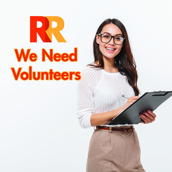 Photo of a young woman wearing glasses and holding a clip board with the words "We need volunteers" next to her.
